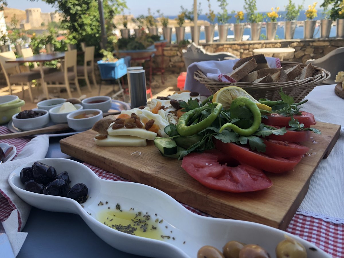 A Turkish breakfast spread with bread, vegetables, olives and cheeses